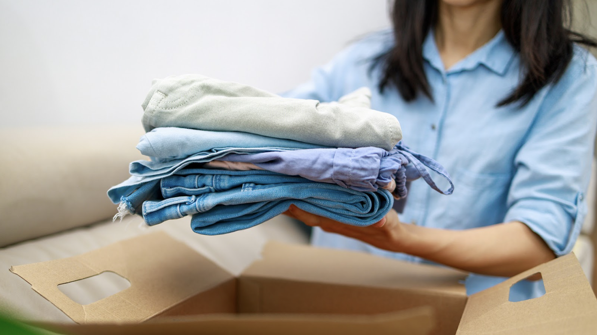 Goodwill AZ | Someone looking through racks of white shirts on hangers